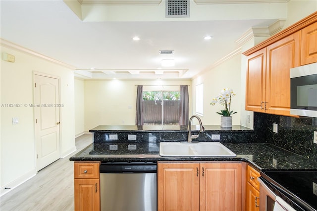 11647 NE 18th Dr Unit 11647, North Miami, FL 33181 - kitchen with stainless steel appliances, a peninsula, light wood-style floors, crown molding, and dark stone countertops