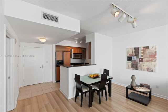 335 S Biscayne Blvd Unit 3410, Miami, FL 33131 - dining space with track lighting, light wood finished floors, and a textured ceiling