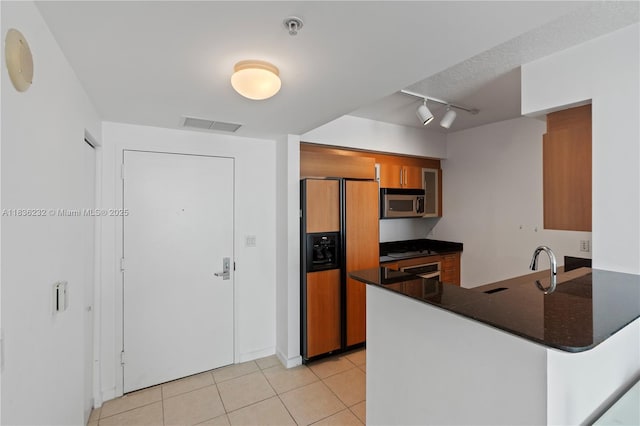 335 S Biscayne Blvd Unit 3410, Miami, FL 33131 - kitchen with paneled built in refrigerator, stainless steel microwave, brown cabinetry, a peninsula, and light tile patterned floors