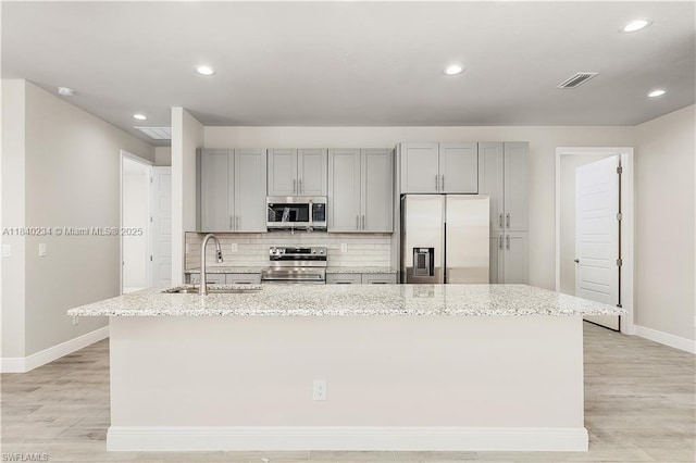 131 N Bethlehem Pl, La Belle, FL 33935 - kitchen featuring appliances with stainless steel finishes, gray cabinetry, an island with sink, light wood-type flooring, and recessed lighting
