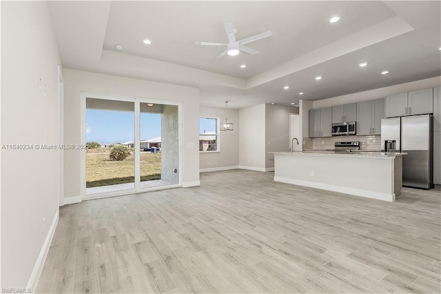131 N Bethlehem Pl, La Belle, FL 33935 - unfurnished living room featuring a tray ceiling, light wood-type flooring, recessed lighting, and ceiling fan