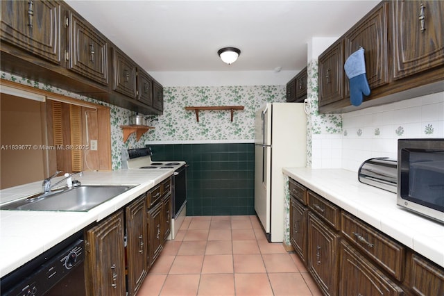 13935 SW 84th St Unit 905, Miami, FL 33183 - kitchen with wallpapered walls, white appliances, tile counters, dark brown cabinetry, and a wainscoted wall