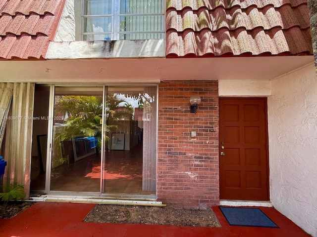 13935 SW 84th St Unit 905, Miami, FL 33183 - view of exterior entry with stucco siding and a tile roof