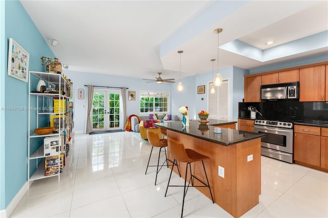 2919 Coconut Ave Unit 1, Miami, FL 33133 - kitchen featuring appliances with stainless steel finishes, decorative backsplash, open floor plan, a center island, and a kitchen breakfast bar