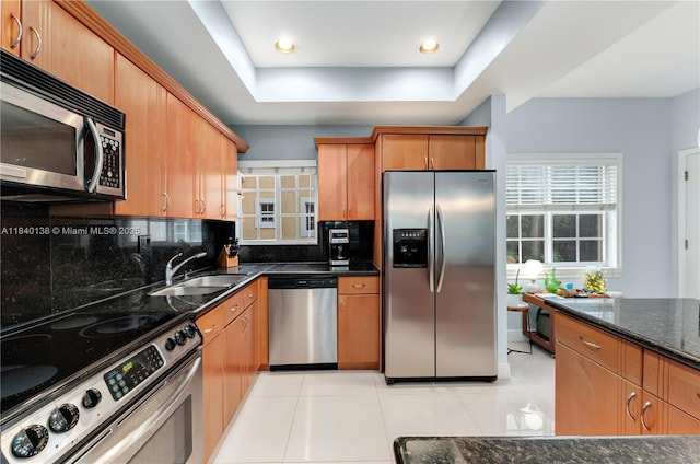 2919 Coconut Ave Unit 1, Miami, FL 33133 - kitchen featuring appliances with stainless steel finishes, a tray ceiling, dark stone countertops, backsplash, and light tile patterned flooring