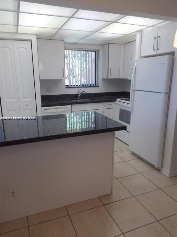 6900 SW 39th St Unit 208J, Davie, FL 33314 - kitchen featuring white appliances, white cabinetry, light tile patterned flooring, and dark stone counters