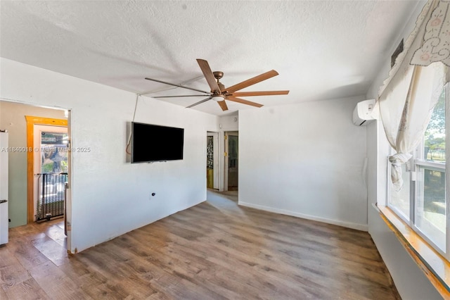 29351 Idaho Rd, Homestead, FL 33033 - unfurnished living room featuring ceiling fan, a textured ceiling, wood finished floors, and an AC wall unit