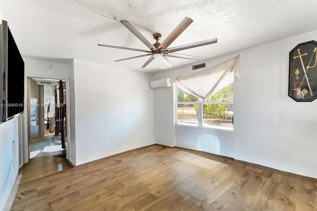 29351 Idaho Rd, Homestead, FL 33033 - spare room featuring wood finished floors, a wall mounted AC, a textured ceiling, and ceiling fan
