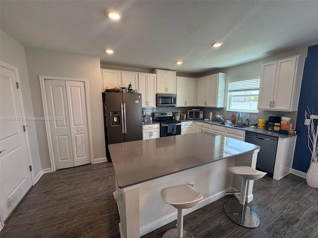 144 Taft Dr, Davenport, FL 33837 - kitchen with appliances with stainless steel finishes, white cabinets, dark wood-style floors, a textured ceiling, and recessed lighting