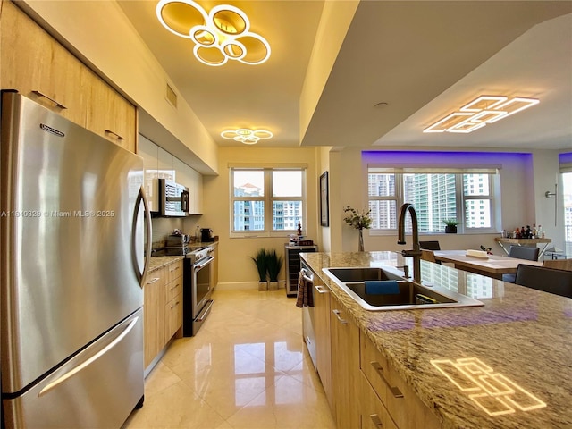 19900 E Country Club Dr Unit 1220, Aventura, FL 33180 - kitchen featuring appliances with stainless steel finishes, plenty of natural light, light stone counters, and light brown cabinets