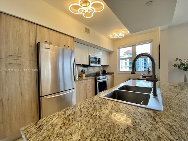19900 E Country Club Dr Unit 1220, Aventura, FL 33180 - kitchen featuring appliances with stainless steel finishes, decorative backsplash, light stone counters, light brown cabinetry, and modern cabinets
