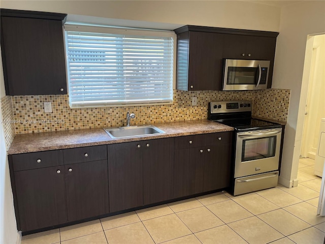 80 W 20th St, Hialeah, FL 33010 - kitchen featuring appliances with stainless steel finishes, decorative backsplash, light tile patterned flooring, dark brown cabinetry, and dark countertops