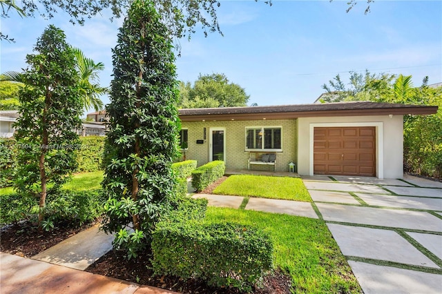 1261 San Miguel Ave, Coral Gables, FL 33134 - view of front facade with brick siding, a garage, and driveway