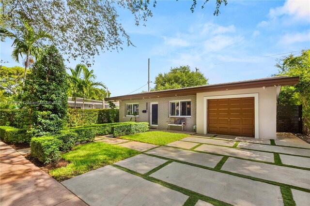 1261 San Miguel Ave, Coral Gables, FL 33134 - ranch-style home featuring an attached garage, driveway, and brick siding