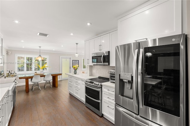 1261 San Miguel Ave, Coral Gables, FL 33134 - kitchen featuring stainless steel appliances, ornamental molding, light countertops, white cabinetry, and recessed lighting