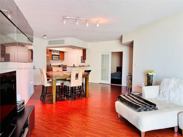 9066 SW 73rd Ct Unit 1409, Miami, FL 33156 - dining space featuring dark wood finished floors, a textured ceiling, and rail lighting