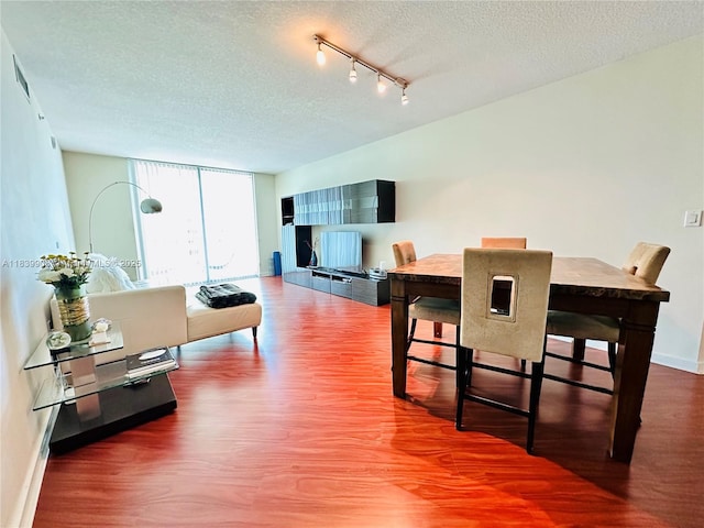 9066 SW 73rd Ct Unit 1409, Miami, FL 33156 - dining area with a textured ceiling, wood finished floors, rail lighting, and a wall of windows