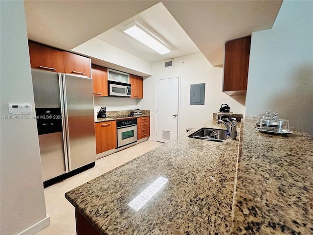 9066 SW 73rd Ct Unit 1409, Miami, FL 33156 - kitchen with appliances with stainless steel finishes, brown cabinets, electric panel, and light stone counters
