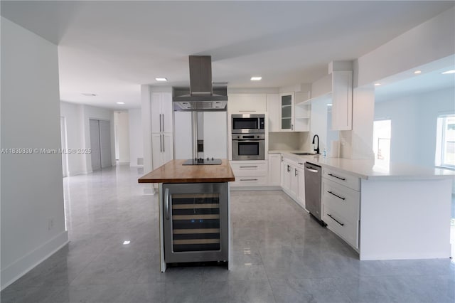 10860 SW 116th St, Miami, FL 33176 - kitchen with stainless steel appliances, beverage cooler, wood counters, island range hood, and white cabinets