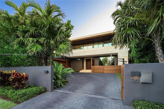 126 W San Marino Dr, Miami Beach, FL 33139 - view of front of house with a gate, a fenced front yard, and stucco siding