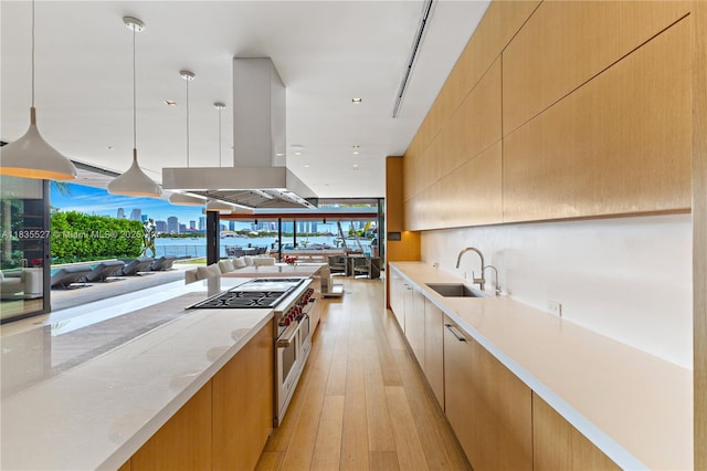 126 W San Marino Dr, Miami Beach, FL 33139 - kitchen with modern cabinets, double oven range, light wood-style flooring, island exhaust hood, and open floor plan
