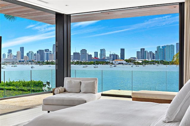 126 W San Marino Dr, Miami Beach, FL 33139 - bedroom featuring a view of skyline, wood finished floors, floor to ceiling windows, a water view, and multiple windows