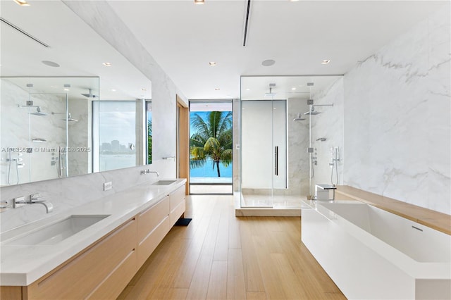126 W San Marino Dr, Miami Beach, FL 33139 - full bathroom featuring a marble finish shower, a freestanding bath, wood finished floors, double vanity, and floor to ceiling windows