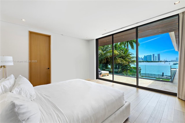 126 W San Marino Dr, Miami Beach, FL 33139 - bedroom with expansive windows, access to outside, wood finished floors, a water view, and a view of skyline