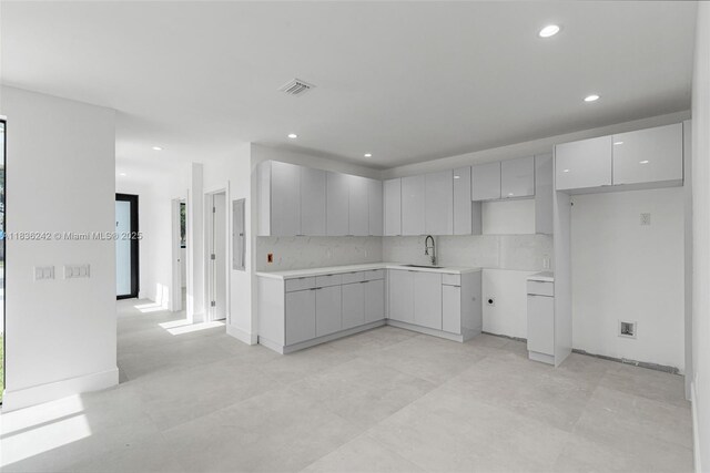 1271 NW 38th St, Miami, FL 33142 - kitchen featuring modern cabinets, recessed lighting, and tasteful backsplash