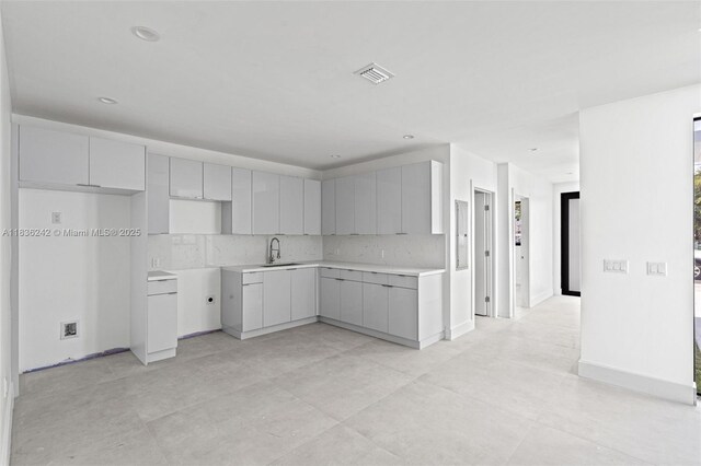 1271 NW 38th St, Miami, FL 33142 - kitchen featuring tasteful backsplash, modern cabinets, and light countertops