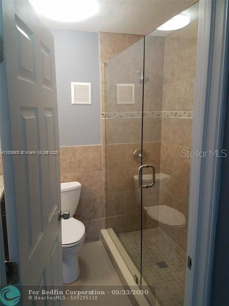 1610 S 22nd Ave, Hollywood, FL 33020 - bathroom with a stall shower, tile walls, and vanity