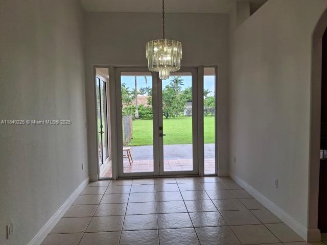 16961 SW 213th Ln, Miami, FL 33187 - entryway with a chandelier, arched walkways, and light tile patterned flooring