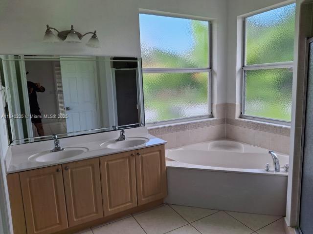 16961 SW 213th Ln, Miami, FL 33187 - full bathroom featuring a garden tub, double vanity, and tile patterned floors