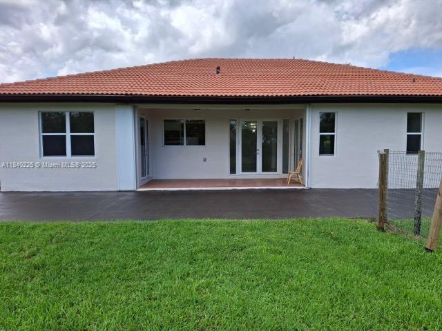 16961 SW 213th Ln, Miami, FL 33187 - rear view of property featuring a tile roof and a patio area