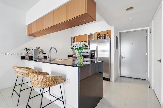 1750 SE Bayshore Dr Unit 2506, Miami, FL 33132 - kitchen featuring appliances with stainless steel finishes, a peninsula, a breakfast bar, dark countertops, and glass insert cabinets