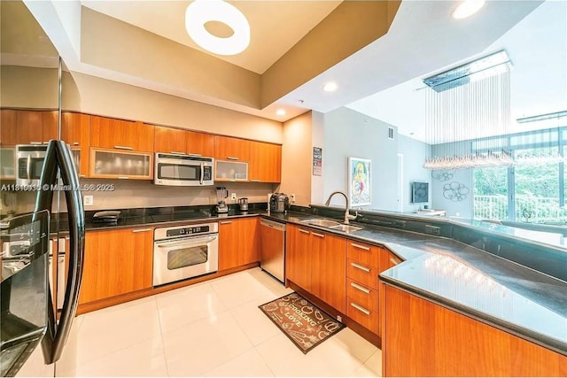 14951 Royal Oaks Ln Unit 102, North Miami, FL 33181 - kitchen with appliances with stainless steel finishes, brown cabinetry, dark countertops, light tile patterned flooring, and recessed lighting
