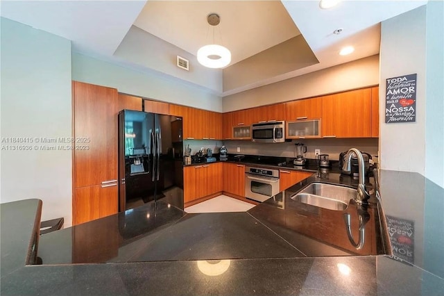 14951 Royal Oaks Ln Unit 102, North Miami, FL 33181 - kitchen with black appliances, brown cabinetry, dark countertops, modern cabinets, and a high ceiling