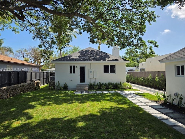 1923 NW 48th St, Miami, FL 33142 - back of house featuring a chimney, a fenced backyard, stucco siding, and entry steps
