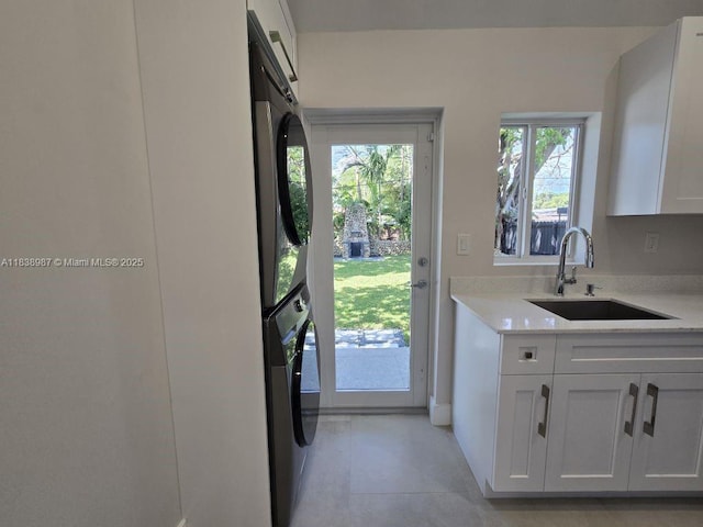 1923 NW 48th St, Miami, FL 33142 - laundry room featuring stacked washer / drying machine, cabinet space, and light tile patterned floors