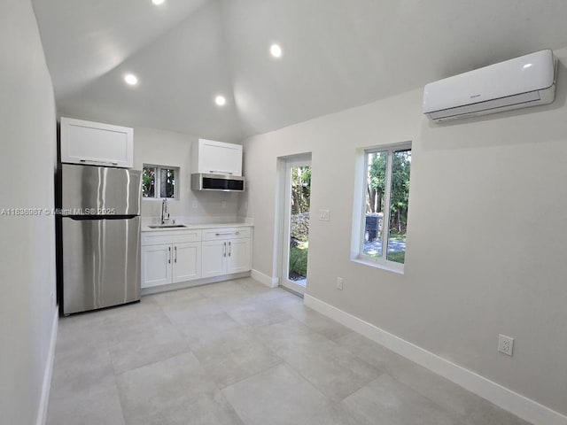 1923 NW 48th St, Miami, FL 33142 - kitchen featuring stainless steel appliances, a wall mounted AC, white cabinetry, light countertops, and vaulted ceiling
