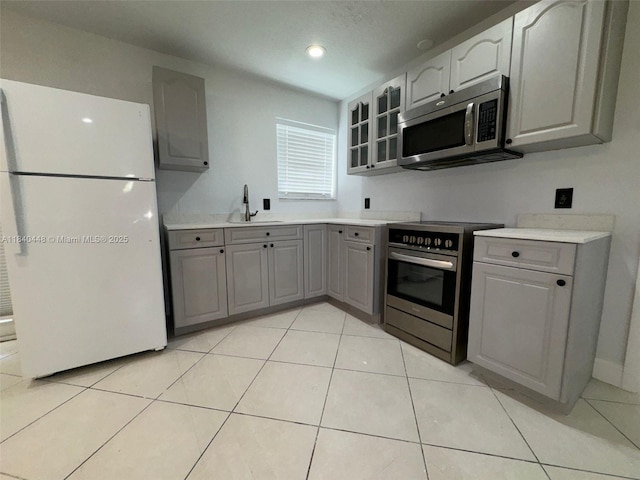 433 SW 28th Ave, Fort Lauderdale, FL 33312 - kitchen with appliances with stainless steel finishes, gray cabinets, glass insert cabinets, light countertops, and recessed lighting