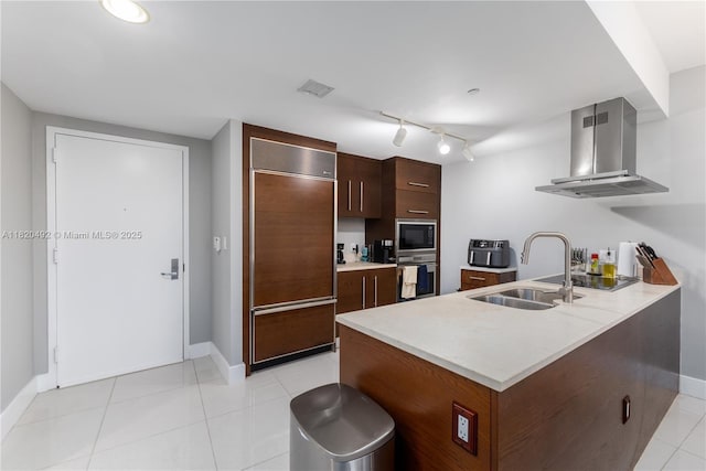 465 Brickell Ave Unit 417, Miami, FL 33131 - kitchen with built in appliances, range hood, light countertops, a peninsula, and light tile patterned flooring