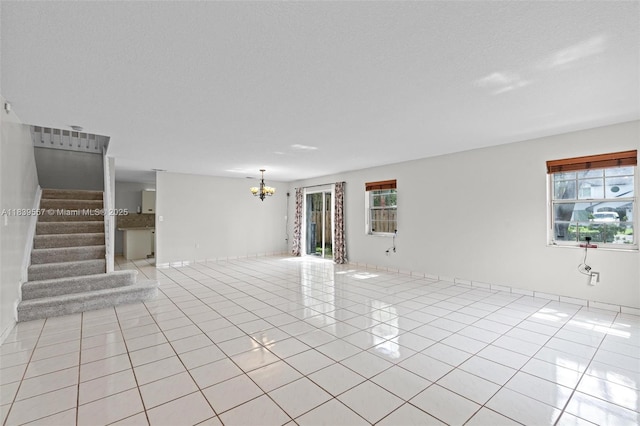 7767 NW 187th Ter, Miami, FL 33015 - unfurnished living room with light tile patterned floors, a chandelier, and stairs