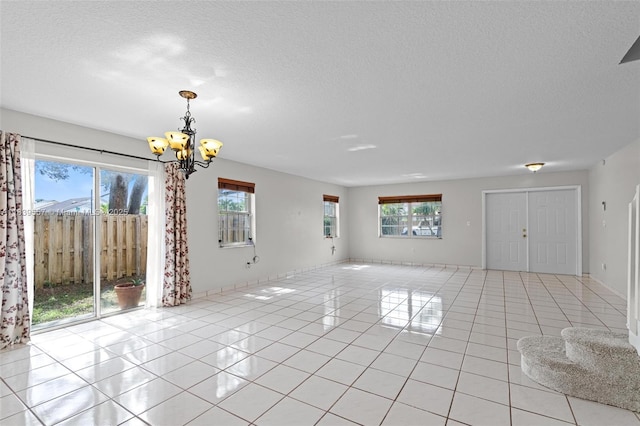 7767 NW 187th Ter, Miami, FL 33015 - unfurnished living room featuring light tile patterned floors, a chandelier, and a textured ceiling