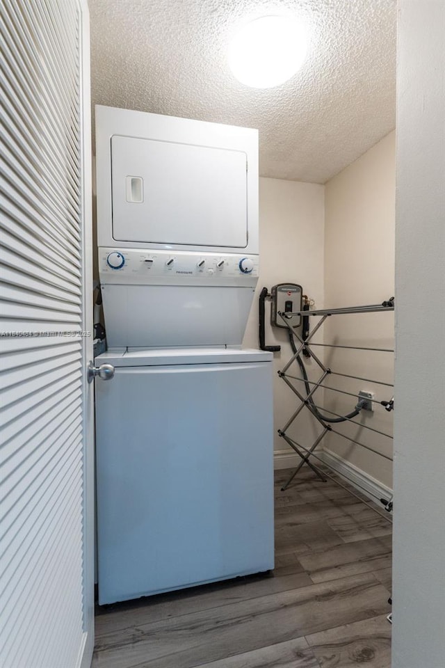 7625 NW 79th Ave Unit 101, Tamarac, FL 33321 - laundry area with stacked washer / drying machine, wood finished floors, and a textured ceiling