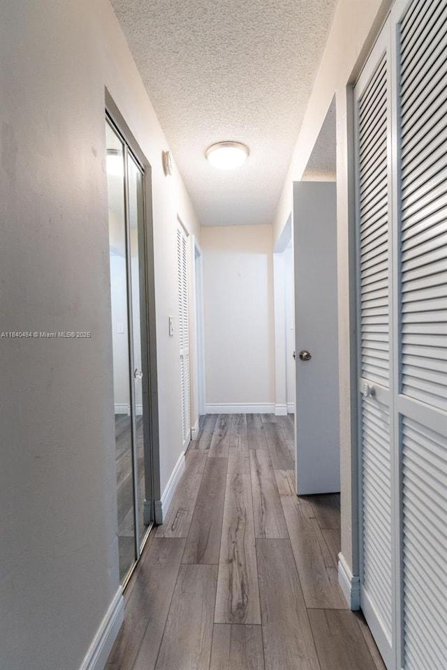 7625 NW 79th Ave Unit 101, Tamarac, FL 33321 - hall featuring a textured ceiling and wood finished floors