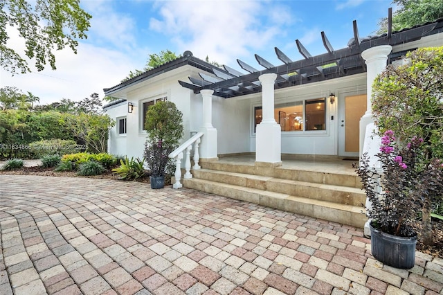 5701 SW 33rd St, Miami, FL 33155 - view of exterior entry with a pergola, a patio area, and stucco siding