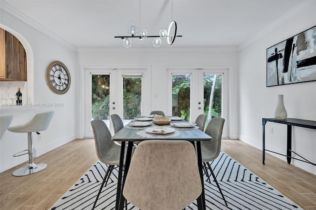 5701 SW 33rd St, Miami, FL 33155 - dining area with french doors, light wood-type flooring, ornamental molding, arched walkways, and a chandelier