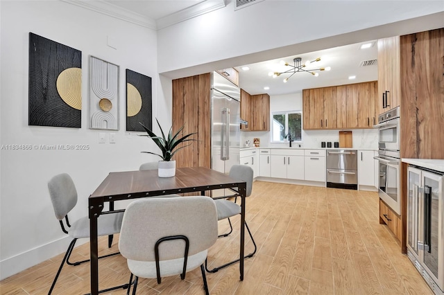 5701 SW 33rd St, Miami, FL 33155 - kitchen featuring wine cooler, light wood finished floors, light countertops, ornamental molding, and a chandelier