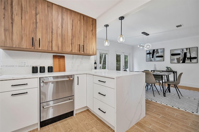 5701 SW 33rd St, Miami, FL 33155 - kitchen with a peninsula, stainless steel dishwasher, light wood-style floors, and hanging light fixtures